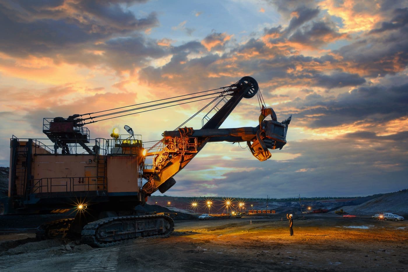 Pelle hydraulique en exploitation sur un site minier au coucher du soleil